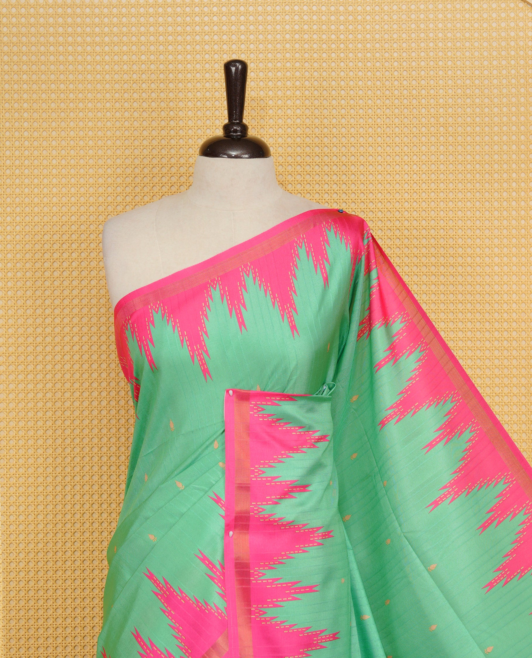 Leaf Green and Rani pink Colour Kattan silk saree featuring buttas all over the body, a temple-designed border &  a contrasting striped pallu with tassels. Paired with a matching contrast-striped blouse piece.