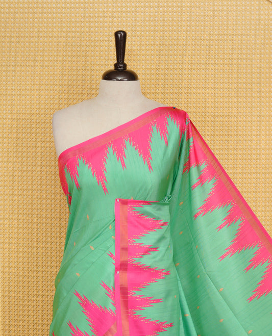 Leaf Green and Rani pink Colour Kattan silk saree featuring buttas all over the body, a temple-designed border &  a contrasting striped pallu with tassels. Paired with a matching contrast-striped blouse piece.