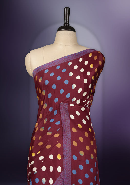 Maroon colour saree with with large big polka dots on the body, self stripped pallu & Comes with a stylish matching blouse.