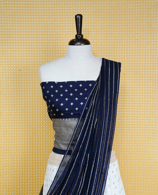 Cream colour Semi Stitched Dhavani Set Cream colour Skirt With Floral Motifs on Border, Paired with Contrast Navy Blue colour With Gold zari motifs on Unstitched Blouse, Elegant Dupatta For Prefect look.