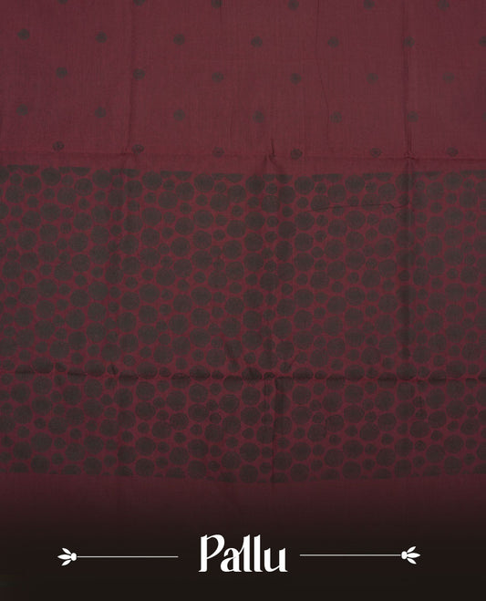 Dark maroon colour poly cotton saree with black abstract butti motifs on the body, paired with a matching pallu with dense black textured round butta pattern, and a coordinated all‑over textured round butta printed blouse piece.