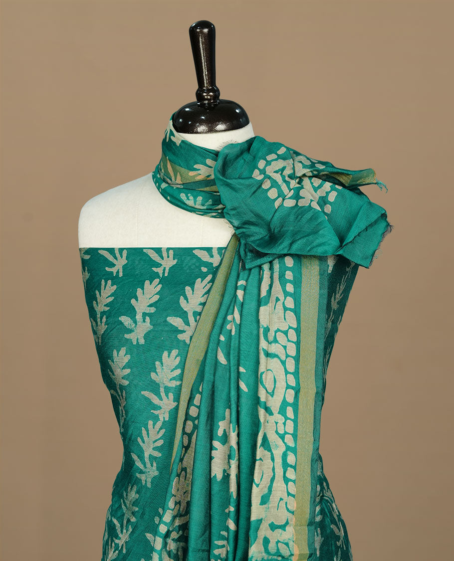 Green colour churidar material featuring cream pattern print on body, paired with matching bottom and dupatta.