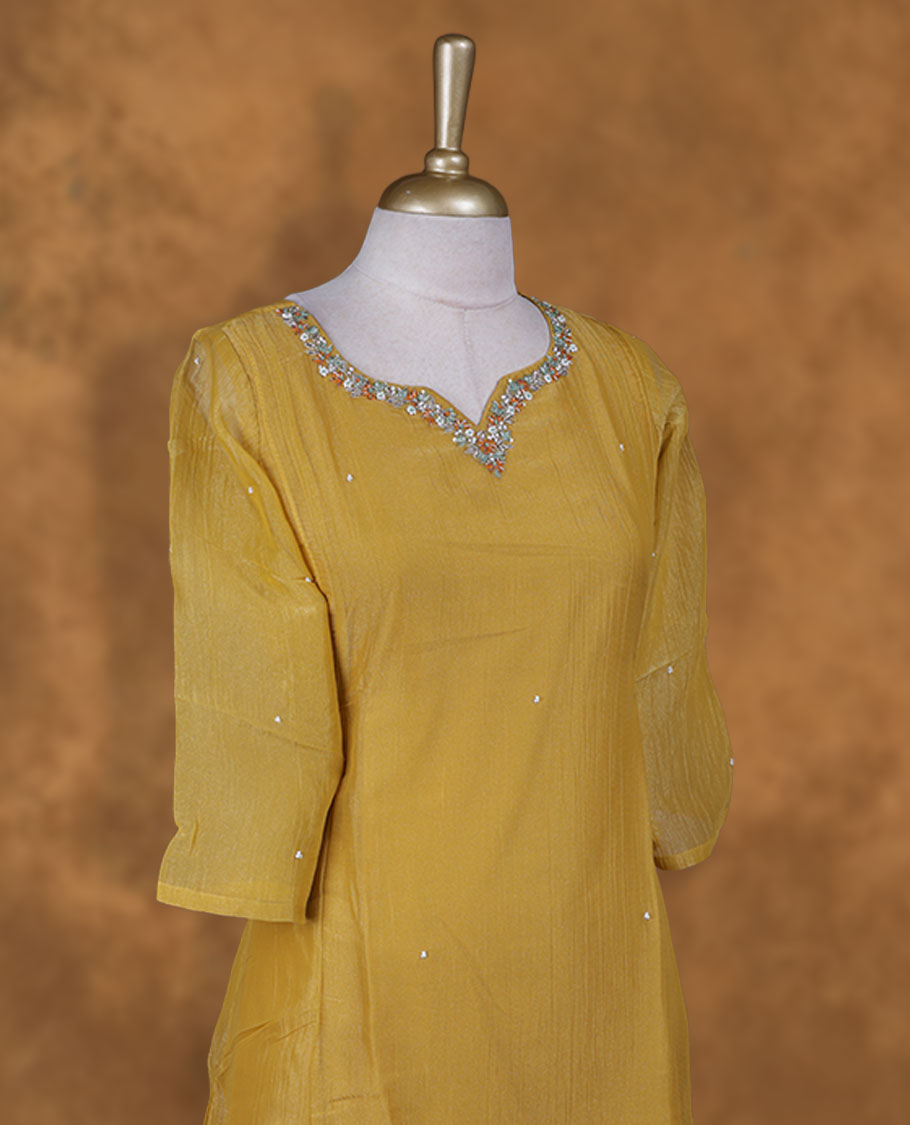 Mustard colour kurti  styled with agold colour thread & beats floral thread pattern Round neckline, knee length design, styled with a Round neckline and a  sleeve .