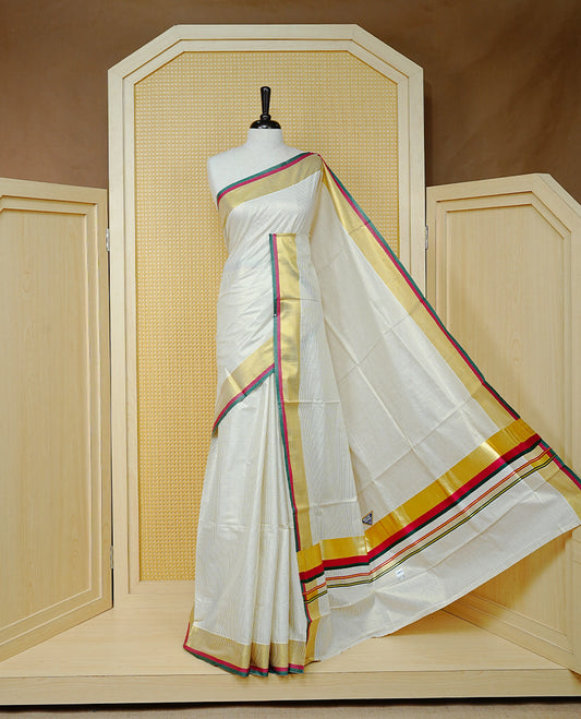 Cream colour cotton Kerala saree Featuring Gold zari Checks across the body, complemented by Classy gold zari with an Maroon  &  Green Border & pallu, paired with a matching blouse piece.