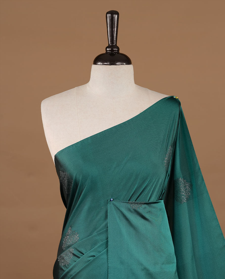 Green colour soft silk saree features a sleek borderless design with intricate antique zari motifs, flowing into a striking contrast Tyrian purple pallu and a matching blouse piece.