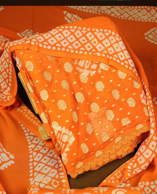 Bright orange colour churidar material featuring elegant gold butta work on the front panel, paired with a printed dupatta and matching bottom.