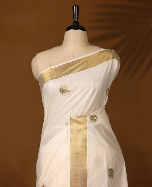 Graceful Kerala Kasavu saree with golden zari motifs and richly woven pallu, the ivory base and elegant border make it perfect for festive and traditional occasions, Pair with temple jewelry for a classic look.