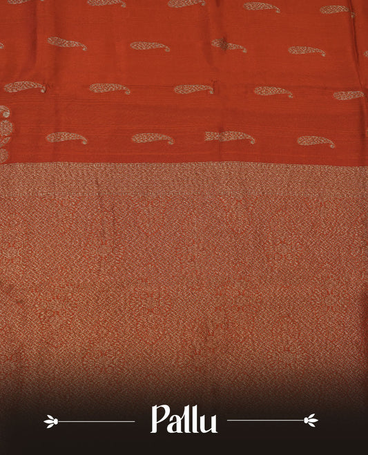 Burnt orange colour semi banaras tussar georgette featuring gold zari leaf pattern across body, finished with gold zari border and paired with matching blouse.