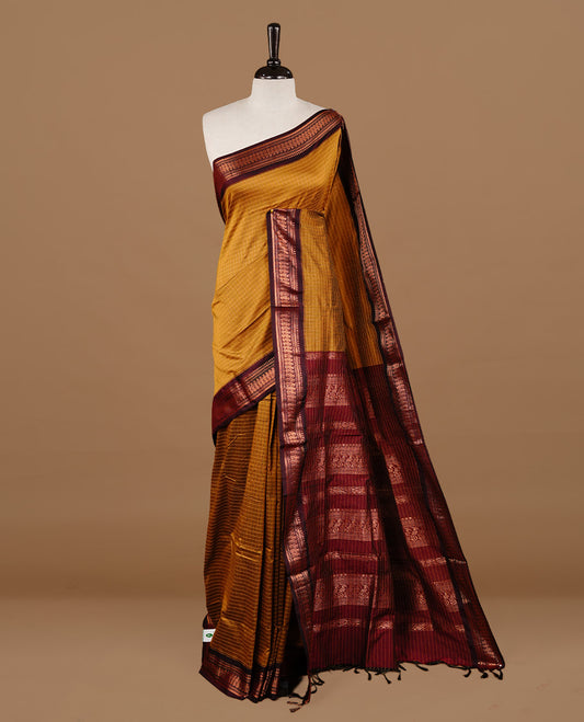 Mustard colour kalyani cotton saree featuring gold zari check pattern on body, highlighting contrast Maroon colour with Antique gold zari border, paired with matching blouse piece.