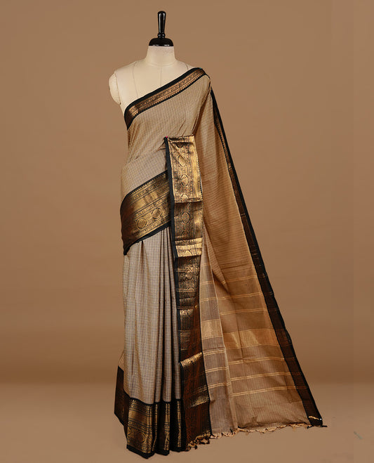 Cream tan colour chettinad cotton saree featuring gold zari motifs on body, complemented by Black colour with zari border, paired with matching blouse piece.