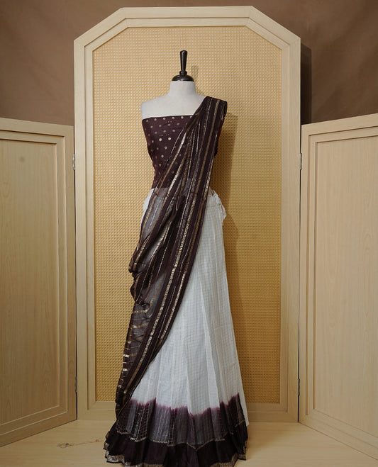 Off white colour Semi stitched dhavani set featuring Gold zari check pattern with contrast Chocolate colour border skirt, paired with matching blouse & dupatta.