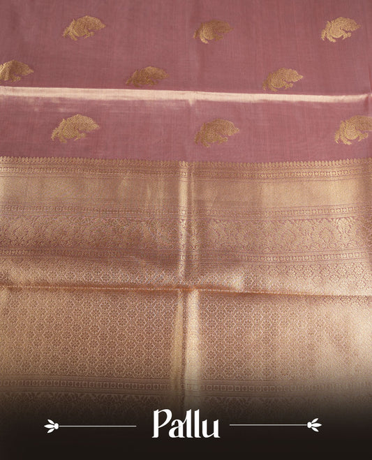 Dual tone light peach and pink colour tissue brocade saree featuring antique gold zari motifs on the body with a rich traditional zari border and pallu, paired with a matching blouse piece.