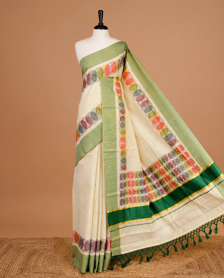 Cream Colour Tissue Kerala Saree Featuring Multicolour Circular Prints Along The Border And Pallu, Complemented By A Light Green Border With Traditional Gold Zari Accents, Paired With A Matching Blouse Piece.
