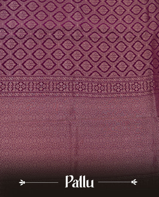 Grape colour banaras satin crepe saree featuring gold zari pattern across body, with self colour border with gold zari pattern and paired with matching blouse.