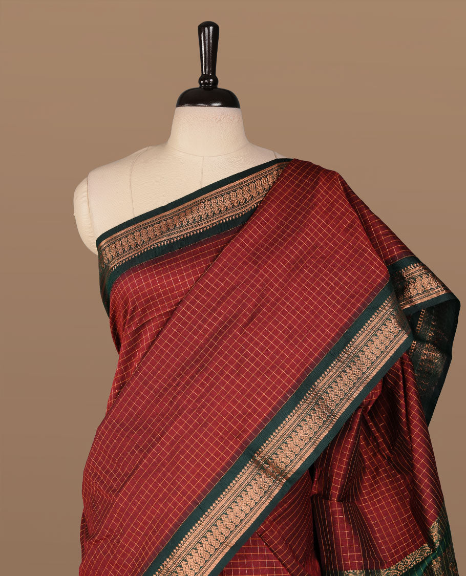 Maroon colour kalyani cotton saree featuring gold zari check pattern on body, complemented by green colour with Antique zari border, paired with matching blouse piece.