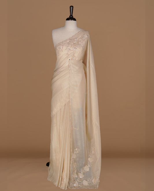 Beige colour net organza saree featuring thread, sequins, cut beats worked on body, highlighting scalp border, paired with matching blouse piece.