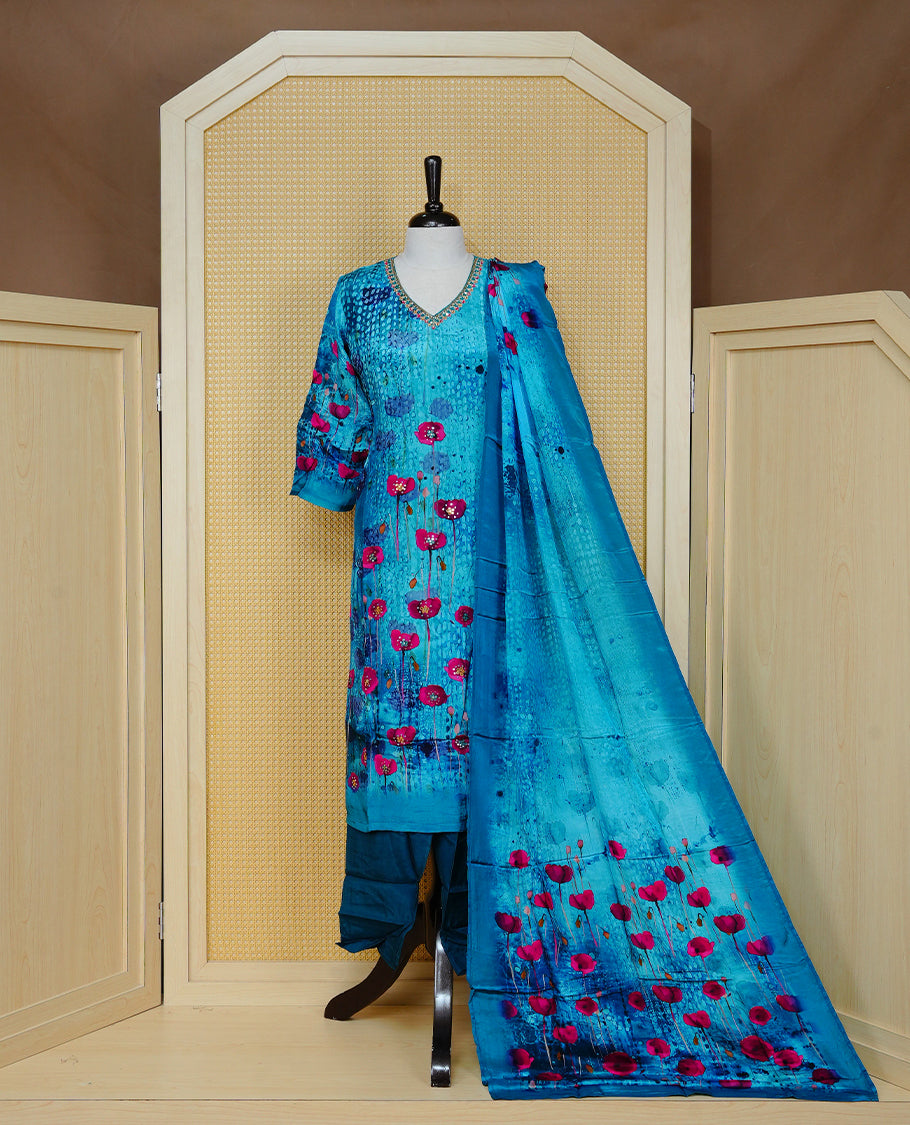Blue colour churidar set featuring vibrant floral prints and delicate bead work on the V-neckline, paired with matching solid pants and a floral printed dupatta.