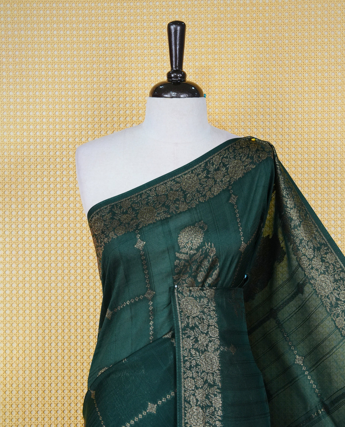 Bottle green colour semi banaras tussar georgette saree featuring gold zari floral pattern on body, finished with gold zari floral motifs on border and paired with matching blouse piece.