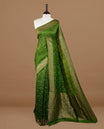 Green colour Banarasi Bandhani silk saree featuring intricate antique zari circle Buttas across the body, complemented by an elegant antique zari border. Comes paired with a matching blouse piece