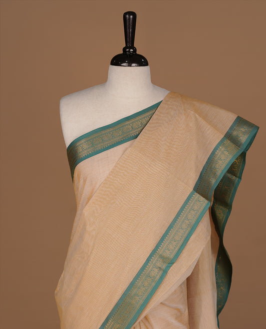 Peachy cream Colour Chettinad cotton saree featuring elegant plain body , complemented by contrast Green colour with simple traditional border, comes with matching blouse piece.