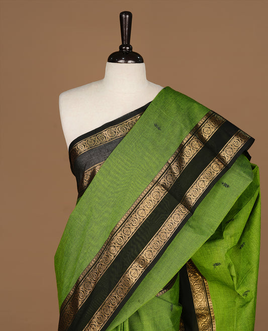 Green colour Chettinad cotton saree featuring motifs on body , complemented by contrast Black colour with zari border, comes with matching blouse piece.