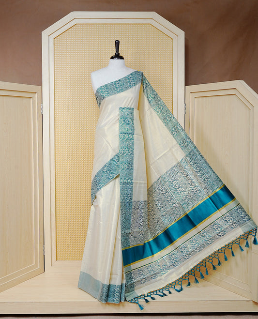 Cream Colour Tissue Kerala Saree Featuring a Plain Body, Enhanced with Sea Green Block  Printed Borders, a Sea Green and Gold Zari Pallu, Sea Green Tassels, and a Matching Blouse Piece.