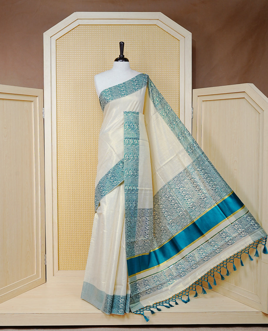 Cream Colour Tissue Kerala Saree Featuring a Plain Body, Enhanced with Sea Green Block  Printed Borders, a Sea Green and Gold Zari Pallu, Sea Green Tassels, and a Matching Blouse Piece.
