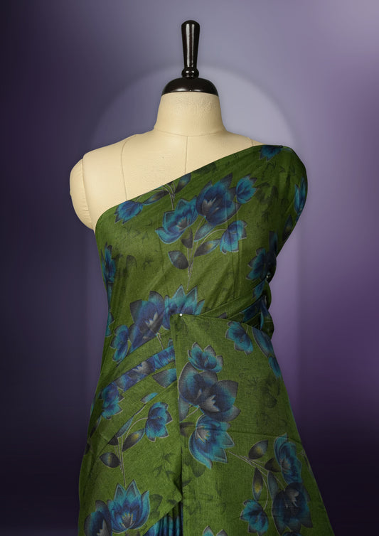 Green colour saree enhanced with a vibrant blue colour floral prints on body & pallu, and  comes with a matching blouse.