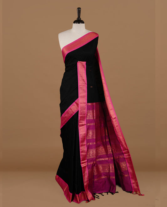 Black colour kalyani cotton saree featuring gold zari motifs on body, highlighting contrast Magenta colour with Antique gold zari border, paired with matching blouse piece.