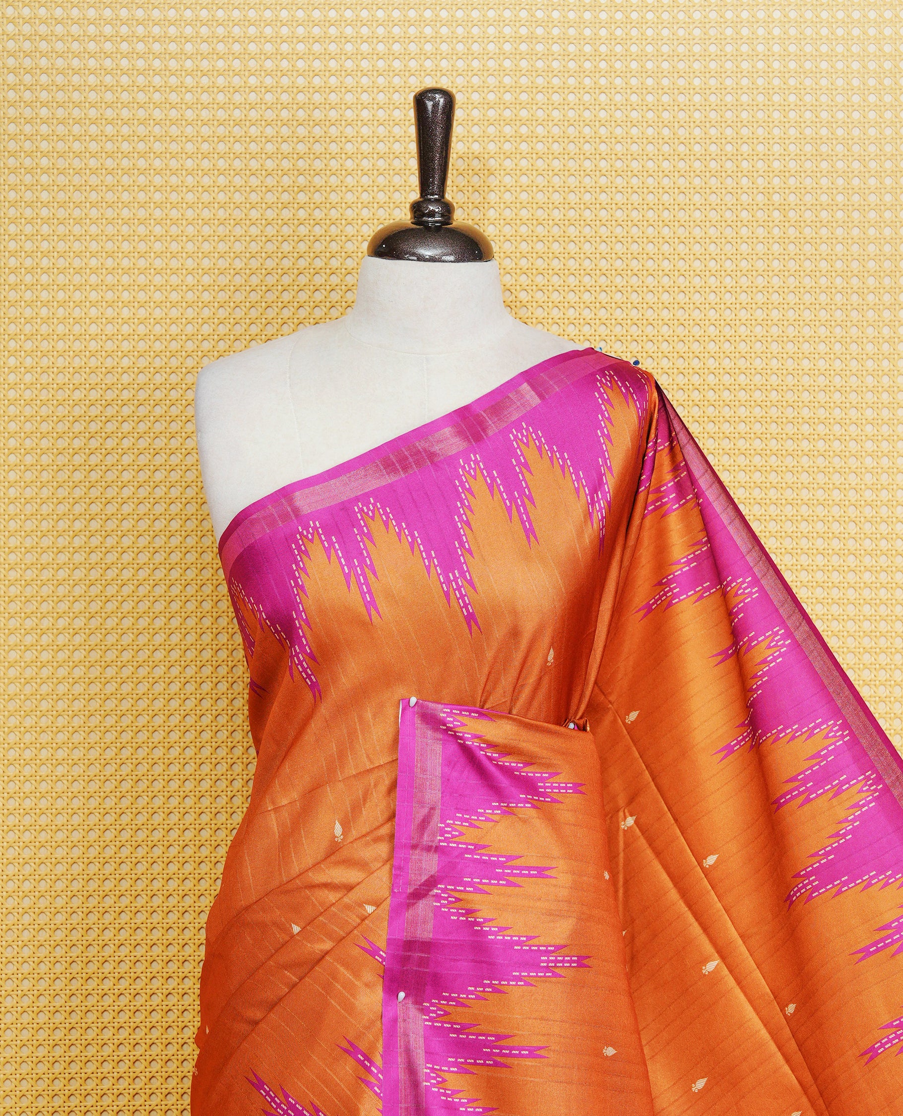 Rust orange and magenta  Colour Kattan silk saree featuring buttas all over the body, a temple-designed border &  a contrasting striped pallu with tassels. Paired with a matching contrast-striped blouse piece.