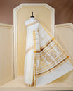 Cream Colour Cotton Kerala Saree Featuring an Elegant Plain Body, a Classy Gold Zari Border, and a Traditional Gold Zari Pallu with Brown Accents, Paired with a Matching Blouse Piece.