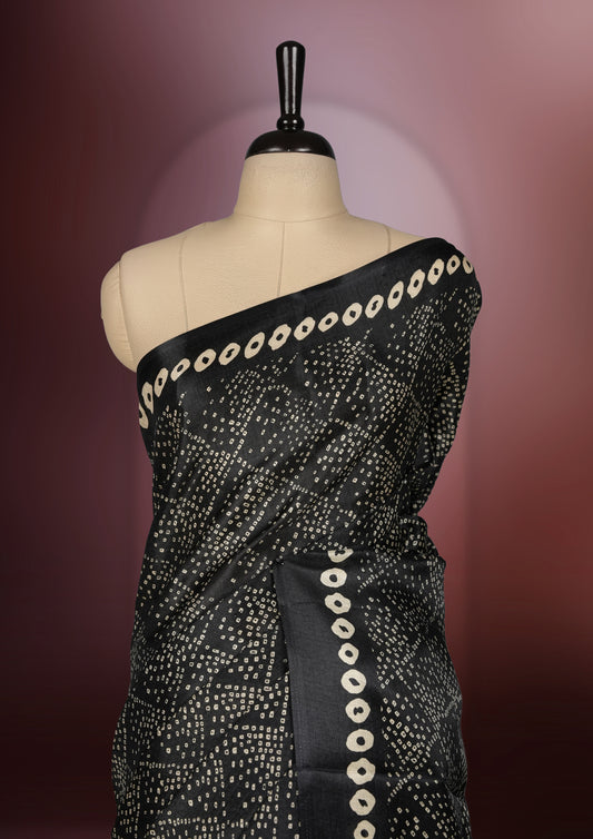 Black colour saree with intricate cream dotted patterns and a striking Madhubani inspired pallu, The soft fabric offers a graceful drape, making it perfect for festive and formal occasions, paired with blouse.