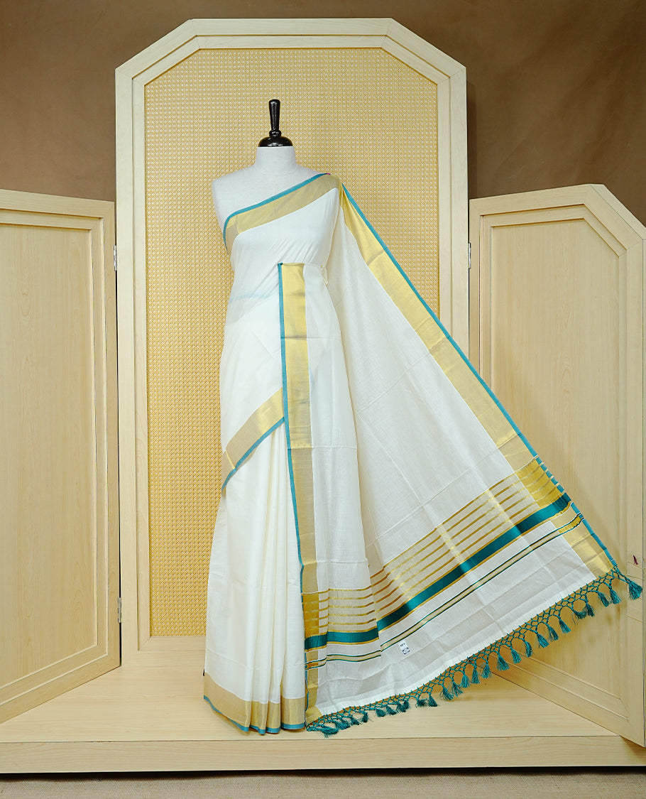 Cream colour Cotton kerala saree featuring Elegant Plain body, complemented by Gold zari with green colour border & Tassel on Pallu, paired with matching blouse piece.