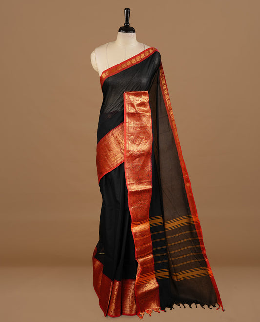 Black colour chettinad cotton saree featuring elegant plain body, complemented by red colour with zari border, paired with matching blouse piece.