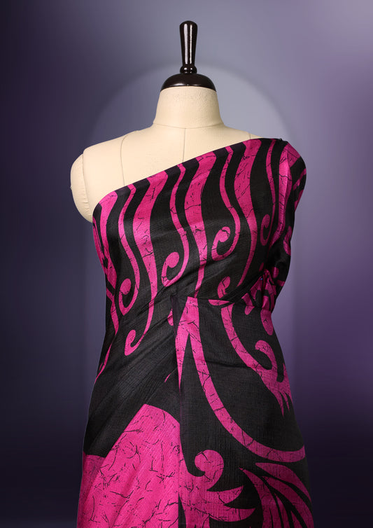 Black and Pink colour semi modal saree featuring bold floral and abstract motifs across the body, complemented by a striking patterned pallu, finished with tassel details and paired with a matching blouse.