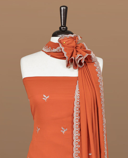 Orange colour churidhar material featuring gold thread floral pattern on body, paired with matching bottom & dupatta.
