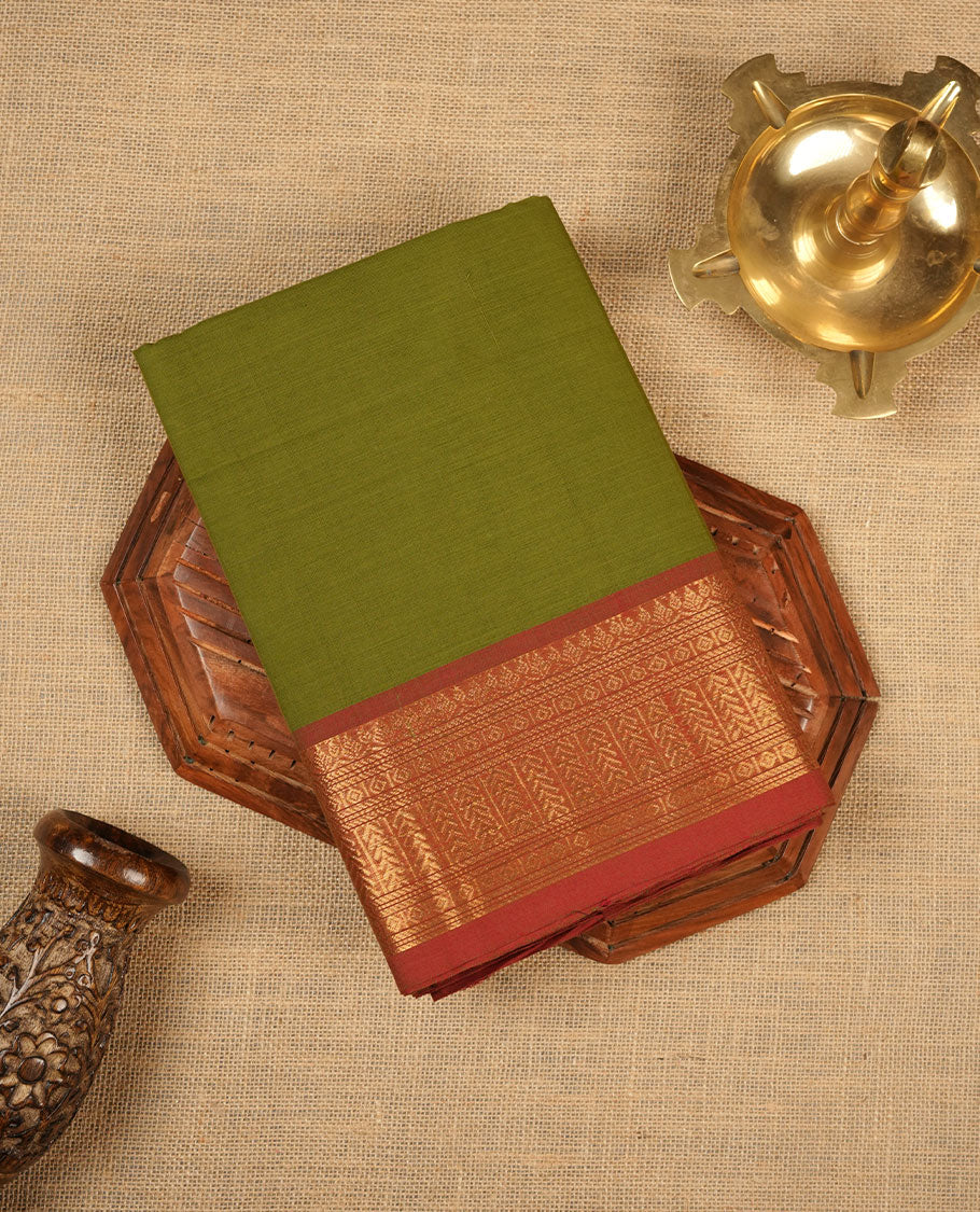 Olive green colour chettinad cotton saree featuring Elegant plain body, contrast Brick red colour border with gold zari border, pallu and paired with matching blouse.