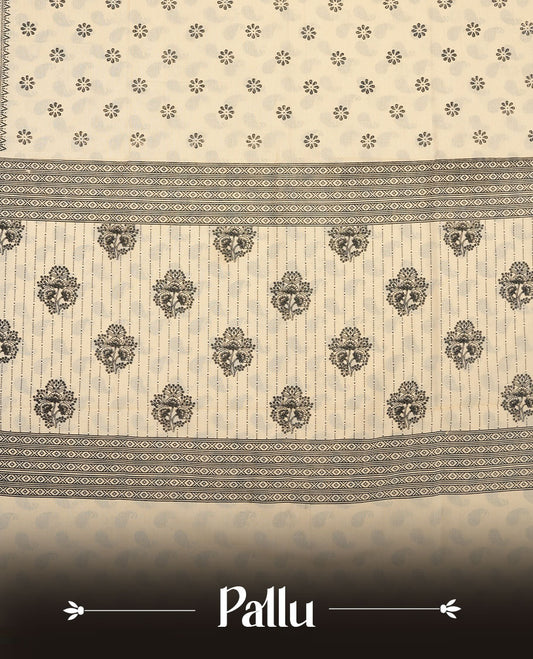 Cream colour poly cotton saree with black floral butti motifs on the body, paired with a matching pallu featuring black ornate floral jaal and stripes on the border, and a coordinated all‑over black paisley printed blouse piece.