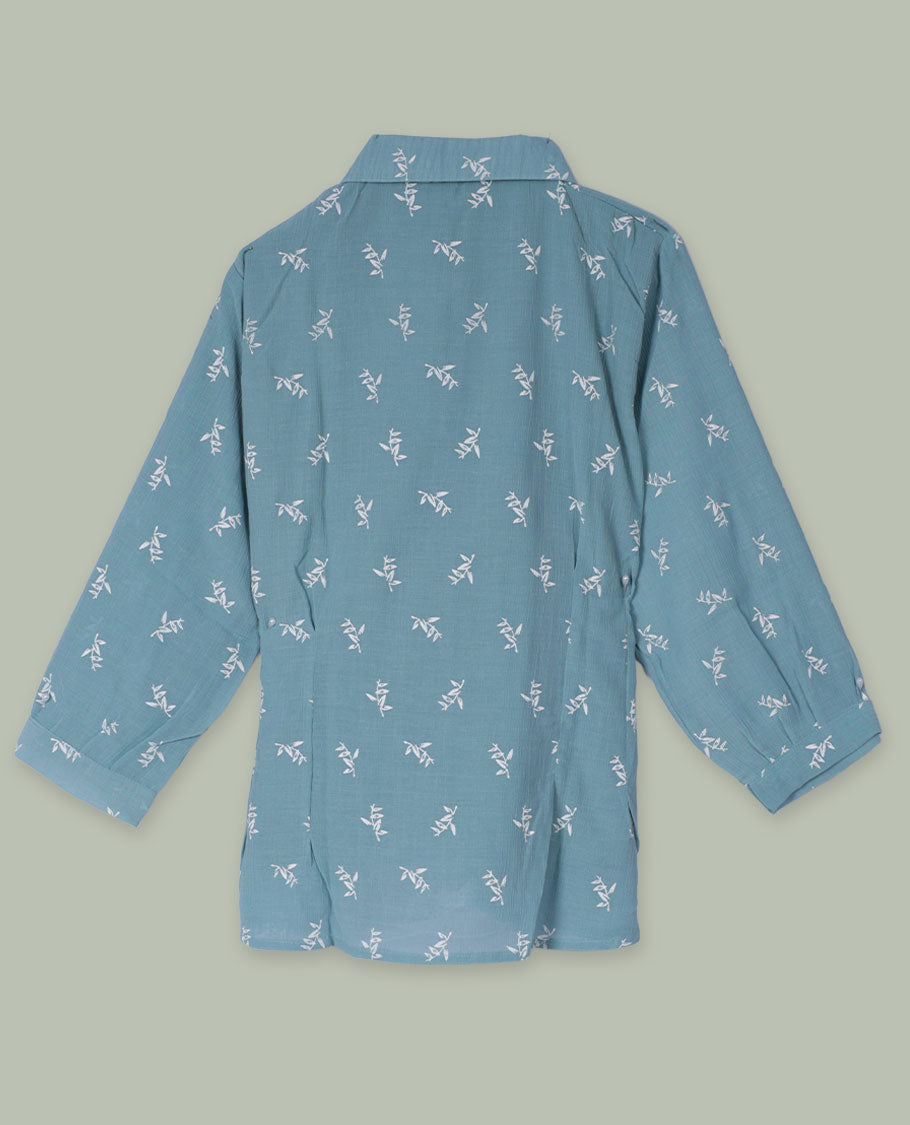 Dusty teal shirt top with all-over tiny white sprig print, collared neckline, three-quarter sleeves, and front button placket framed by a wide scalloped lace panel.