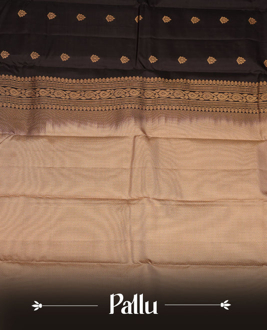 Black colour vasundhara silk saree featuring gold zari buttas on body, complemented by contrast chikku with zari border, paired with  matching blouse piece.