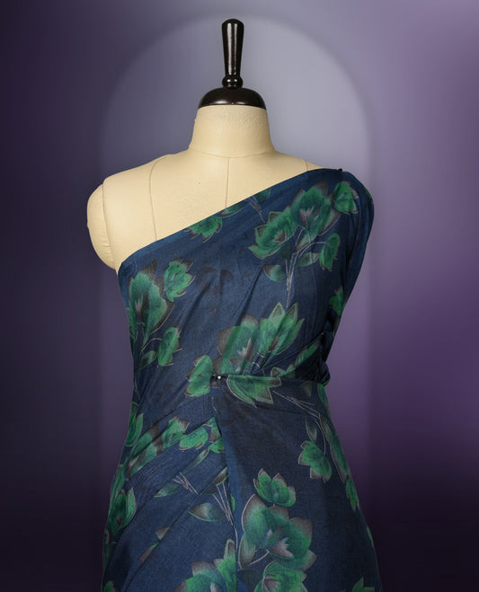 Navy Blue colour saree enhanced with a vibrant green colour floral prints on body & pallu, and  comes with a matching blouse.