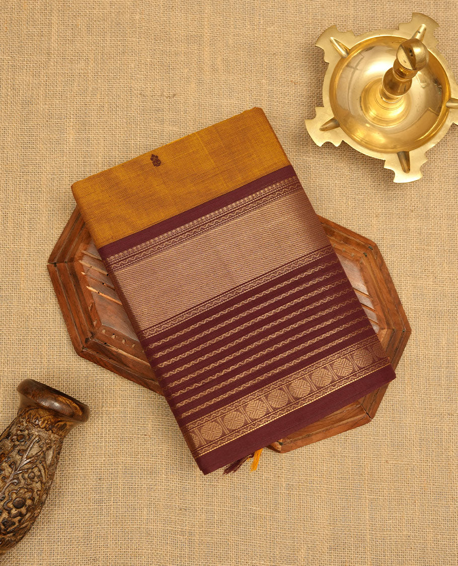 Mustard colour chettinad cotton saree featuring maroon colour motifs on body, contrast maroon colour border with gold zari border, pallu and paired with matching blouse