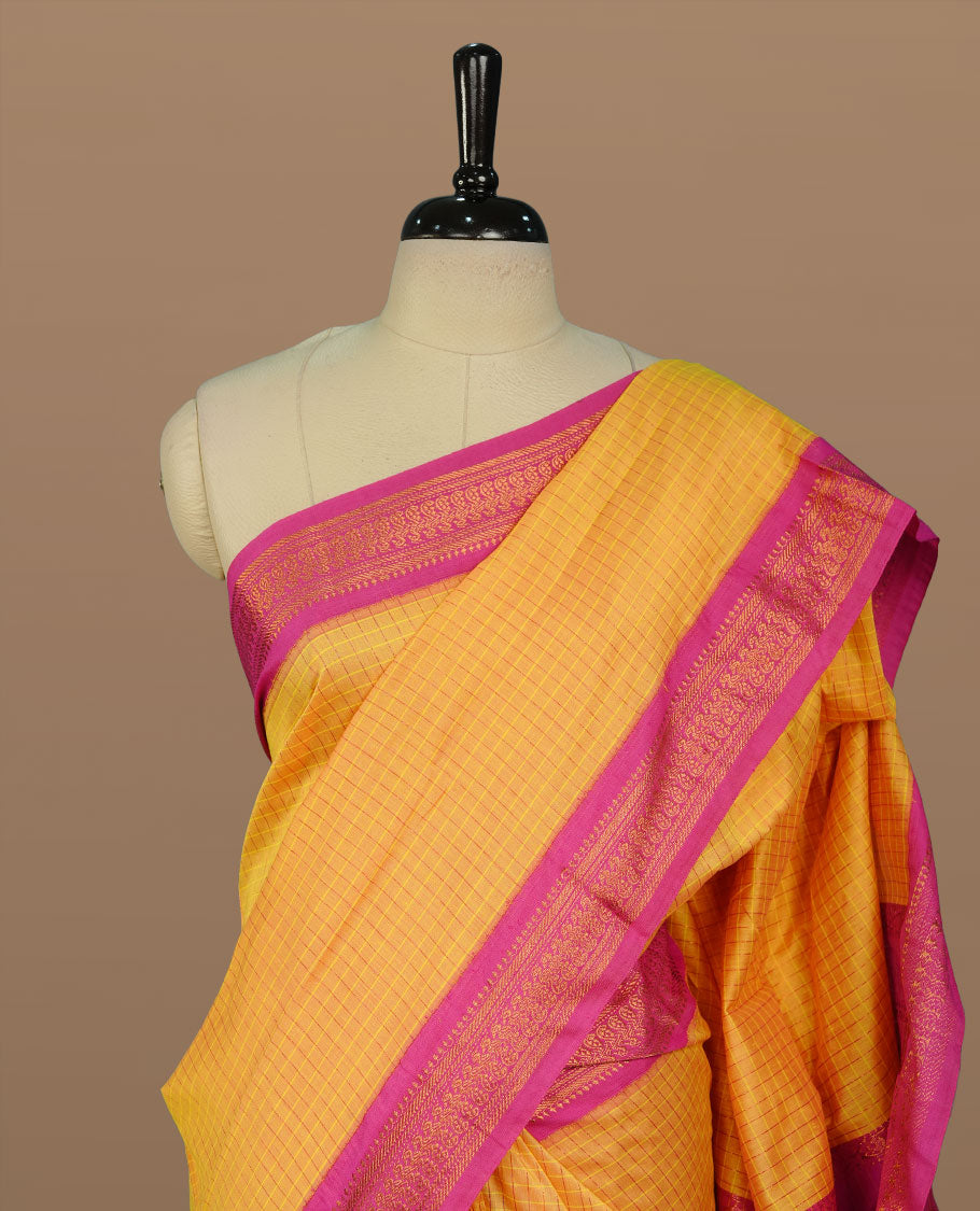 Yellow colour kalyani cotton saree featuring gold zari check pattern on body, complemented by Magenta colour with Antique zari border, paired with matching blouse piece.