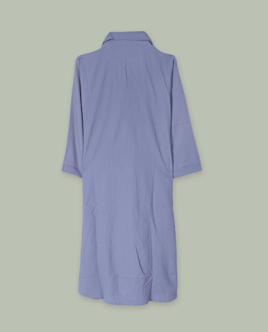 Periwinkle blue open-front shrug with collared neckline and three-quarter sleeves, layered over a white floral graphic tank top.