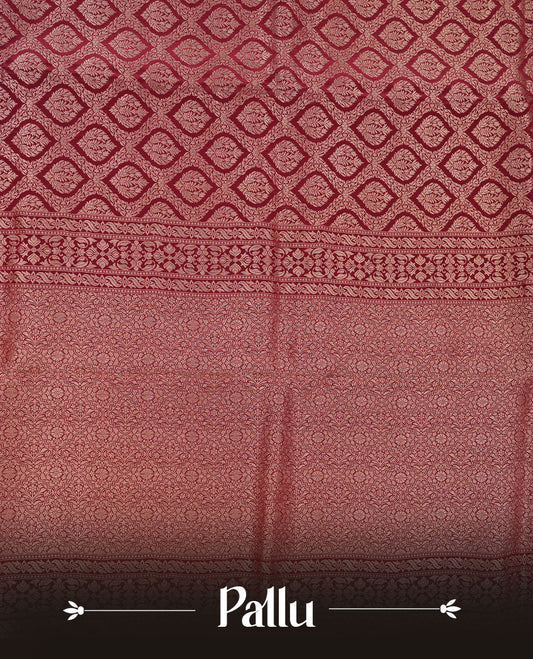 Chocolate brown colour banaras satin crepe saree featuring gold zari pattern across body, with self colour border with gold zari pattern and paired with matching blouse.