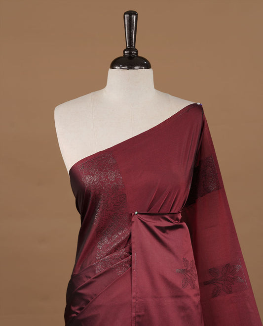Maroon soft silk saree features a sleek borderless design with intricate antique zari motifs, flowing into a seamless self colored pallu and a matching blouse piece.