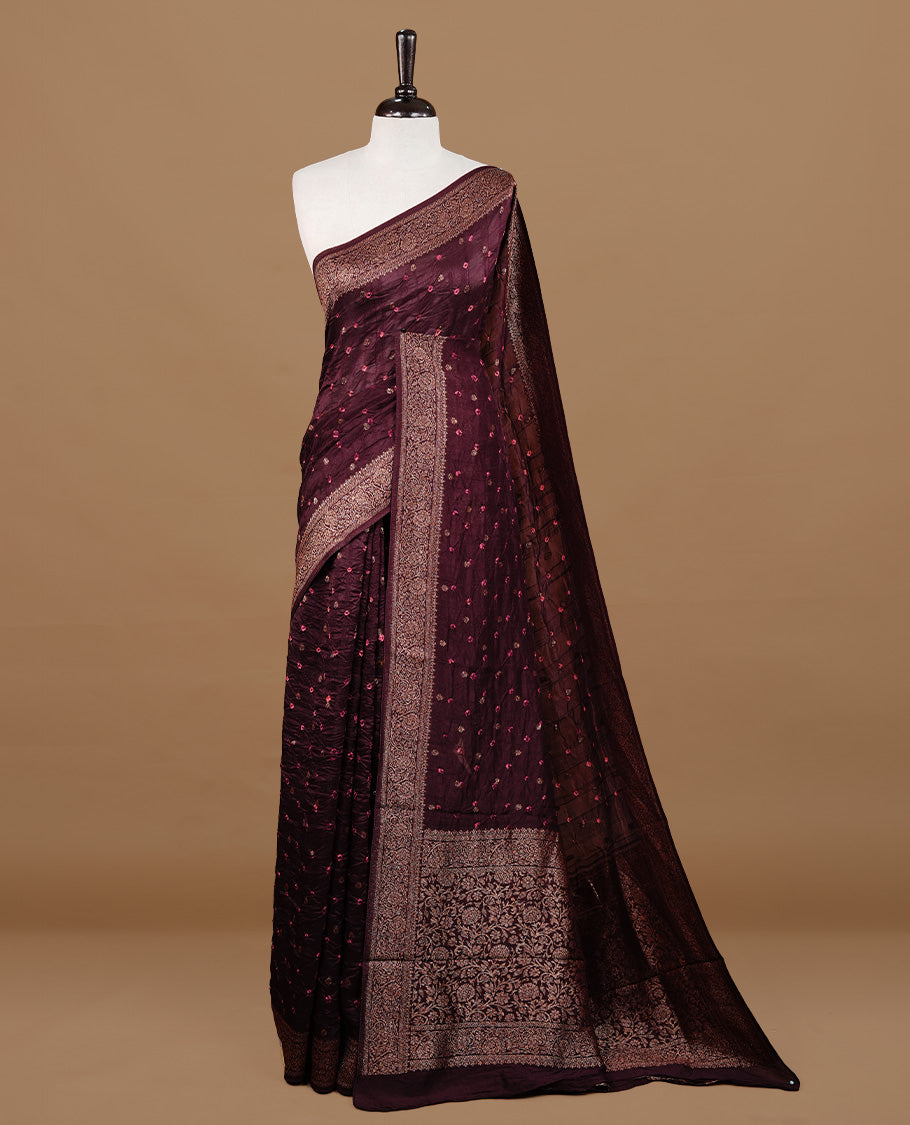 Chocolate brown colour Banarasi Bandhani silk saree featuring intricate antique zari circle Buttas across the body, complemented by an elegant antique zari border. Comes paired with a matching blouse piece