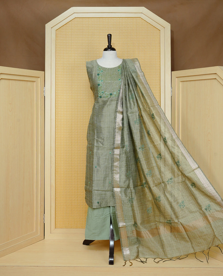 Green colour Tissue Churidar Set featuring delicate floral embroidery and subtle sequin detailing on the yoke, paired with matching solid pants and dupatta.