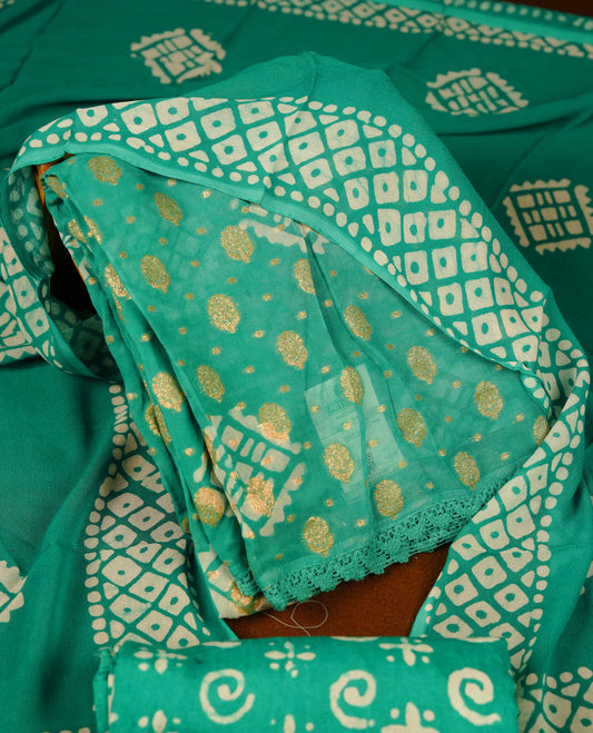 Mint green colour churidar material featuring elegant gold butta work on the front panel, paired with a printed dupatta and matching bottom.