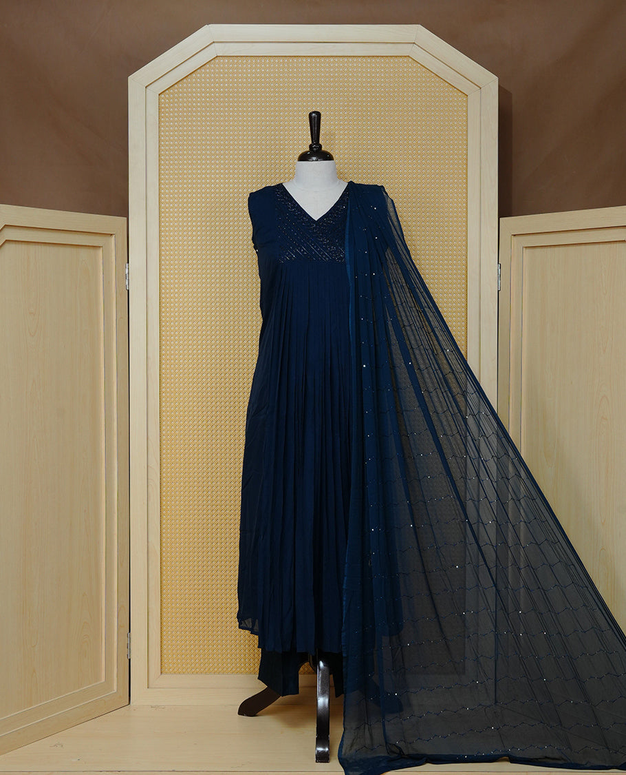Navy blue churidar set with bead work on the V-neckline, paired with a matching embellished dupatta and solid pants.